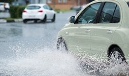 Car driving through flood water.