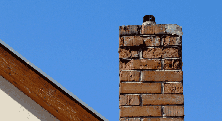 View of a brick chimney against a blue sky