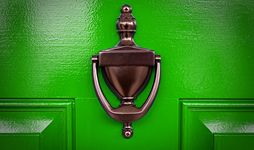 Bright green door with a brass knocker.