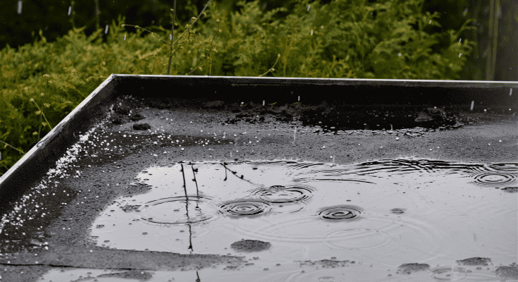 Water pooling on a flat roof in the rain